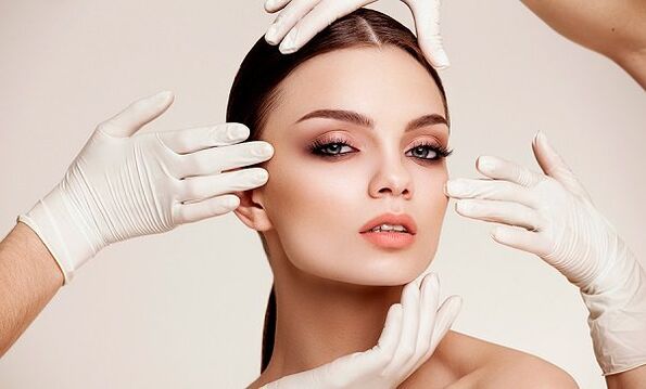 Hands in gloves on the girl's face